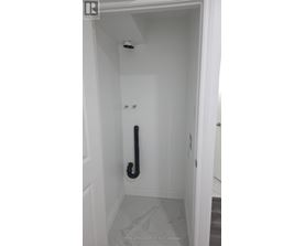A white door with a black handle and a black pipe.