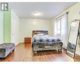 A bedroom with a bed, dresser, and mirror.