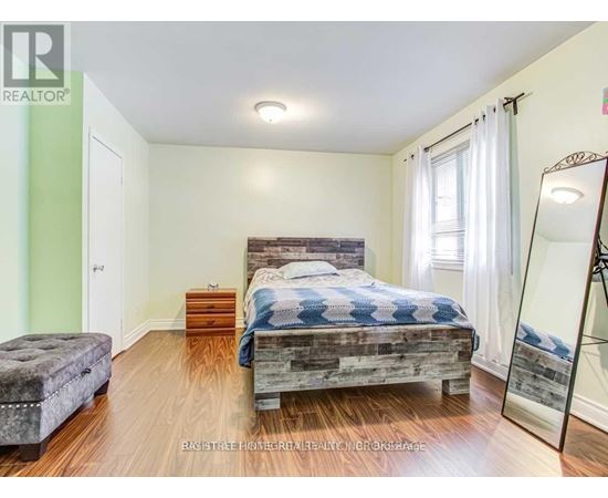 A bedroom with a bed, dresser, and mirror.