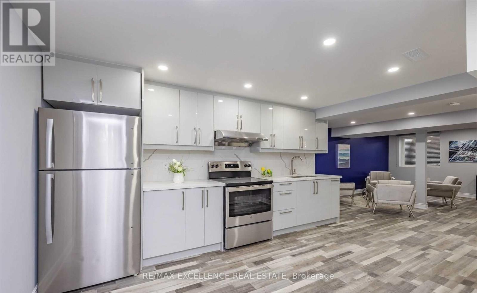 A modern kitchen with a refrigerator, oven, and cabinets.