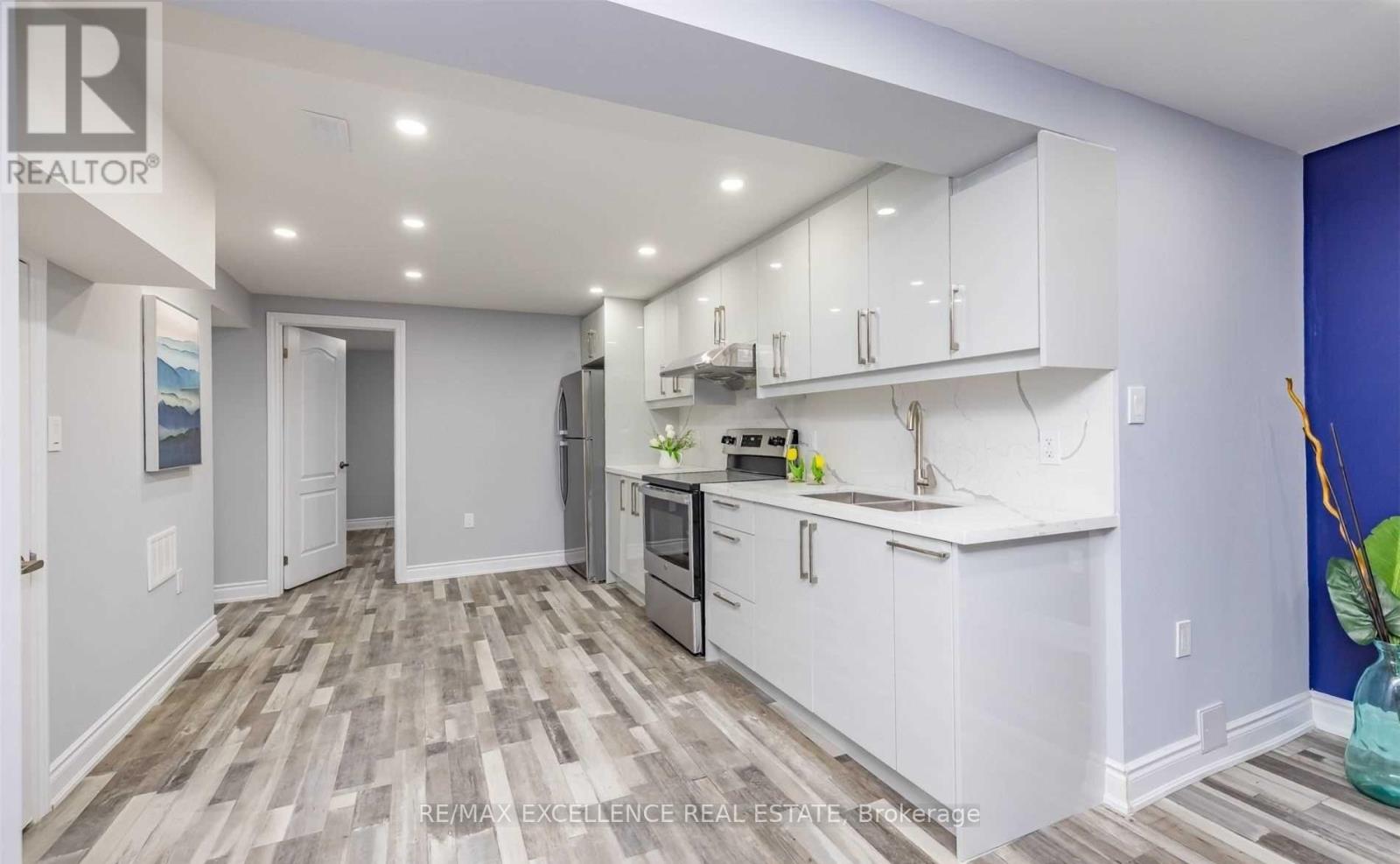 A kitchen with white cabinets and a wooden floor.