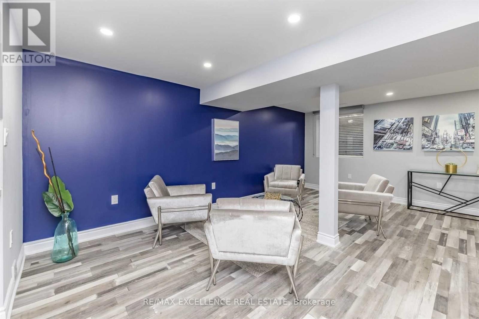 A living room with a blue wall and a wooden floor.