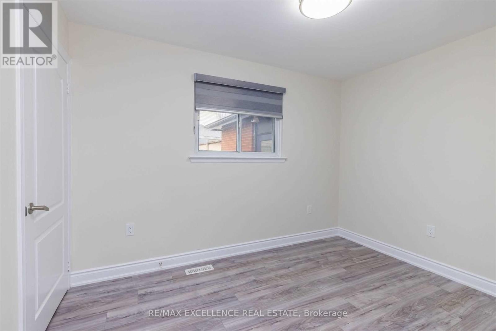 A room with a window and a wooden floor.