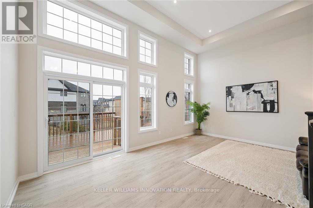 A spacious room with a large window and a view of a house across the way.