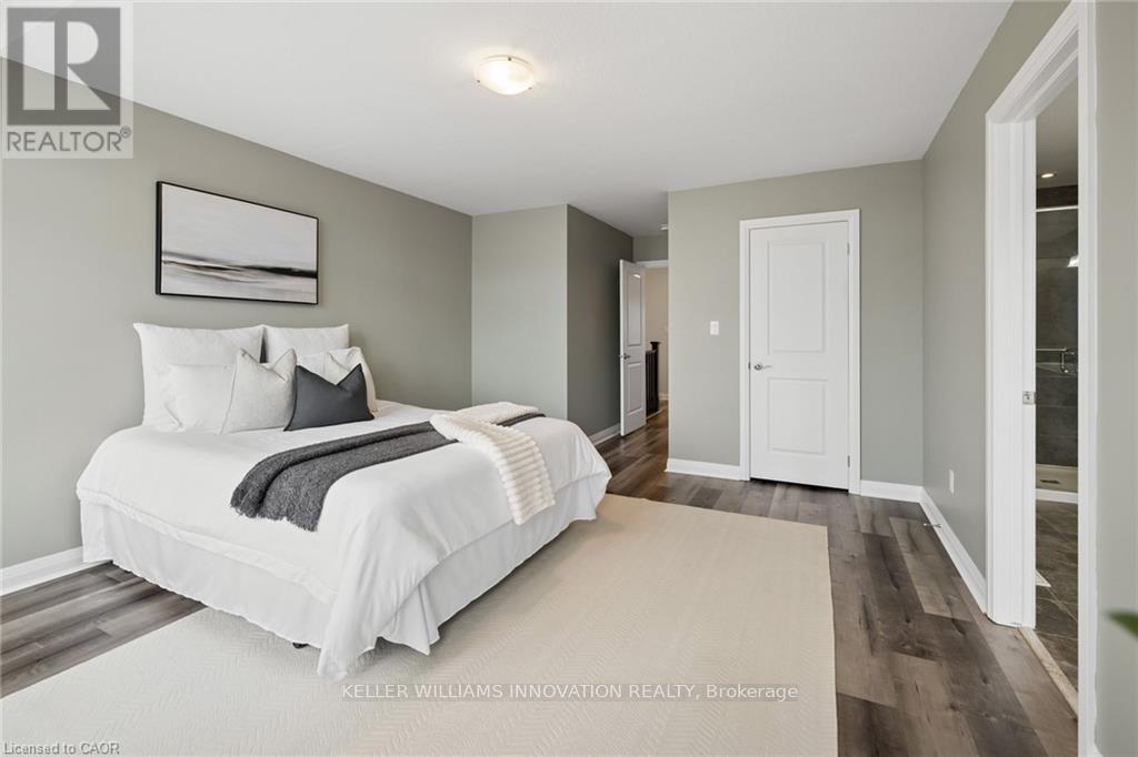 A bedroom with a white bed and a grey headboard.