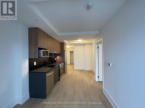A well-lit kitchen with dark wood cabinets and a white countertop.