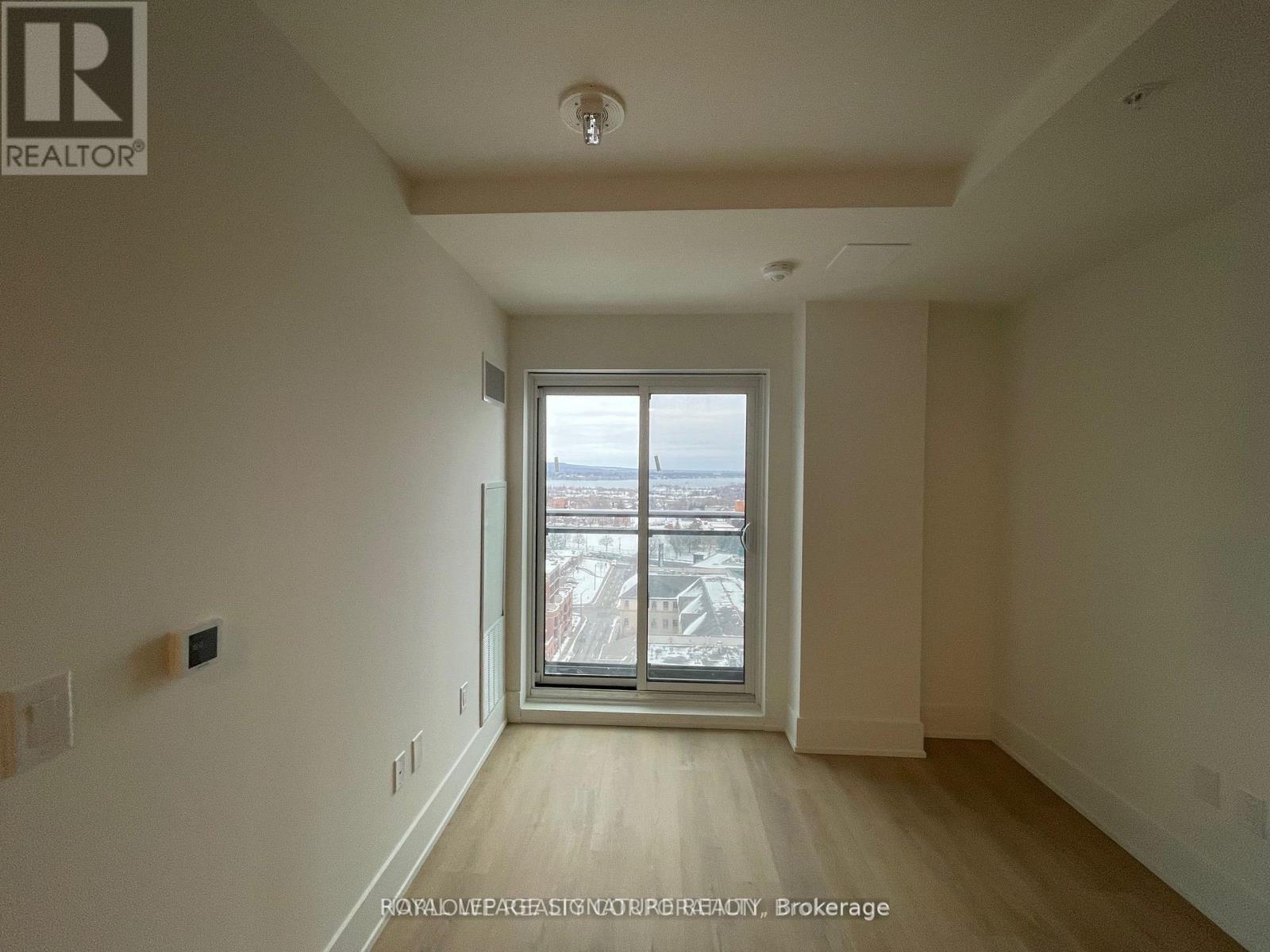 A room with a large window and wooden flooring.