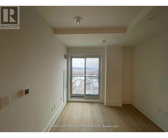A room with a large window and wooden flooring.