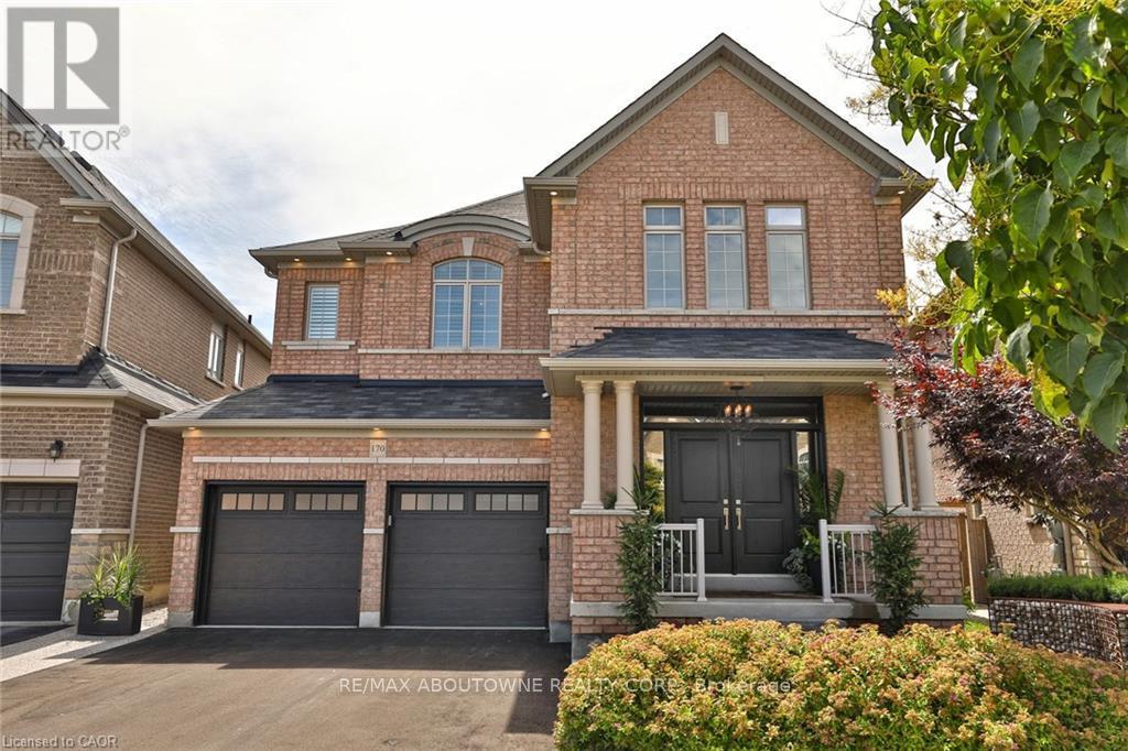 A brick house with a black front door and two garages.