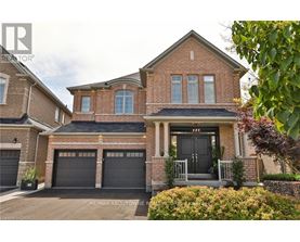 A brick house with a black front door and two garages.