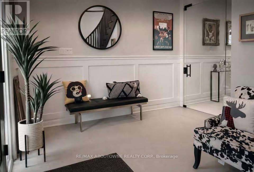 A living room with a black and white sofa, a potted plant, and a framed picture on the wall.
