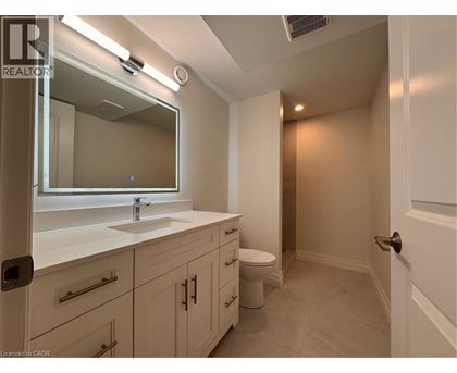 A bathroom with a sink, mirror, and toilet.