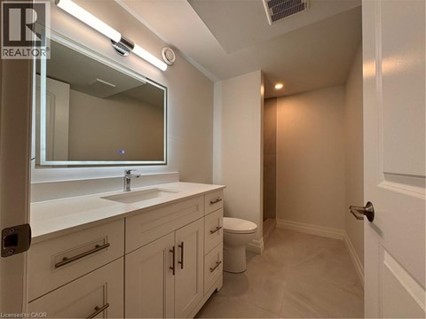 A bathroom with a sink, mirror, and toilet.