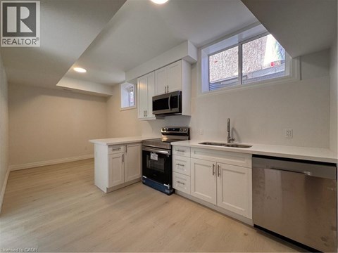 A kitchen with white cabinets and a black oven.