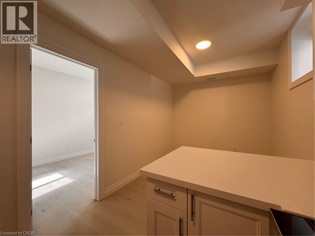 A room with a white countertop and cabinets with a doorway leading to another room.