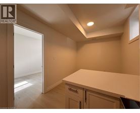 A room with a white countertop and cabinets with a doorway leading to another room.