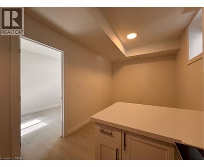 A room with a white countertop and cabinets with a doorway leading to another room.