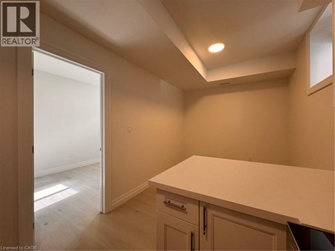 A room with a white countertop and cabinets with a doorway leading to another room.