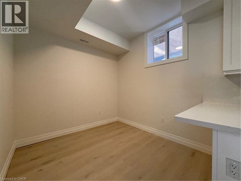 A room with a window and wooden flooring.