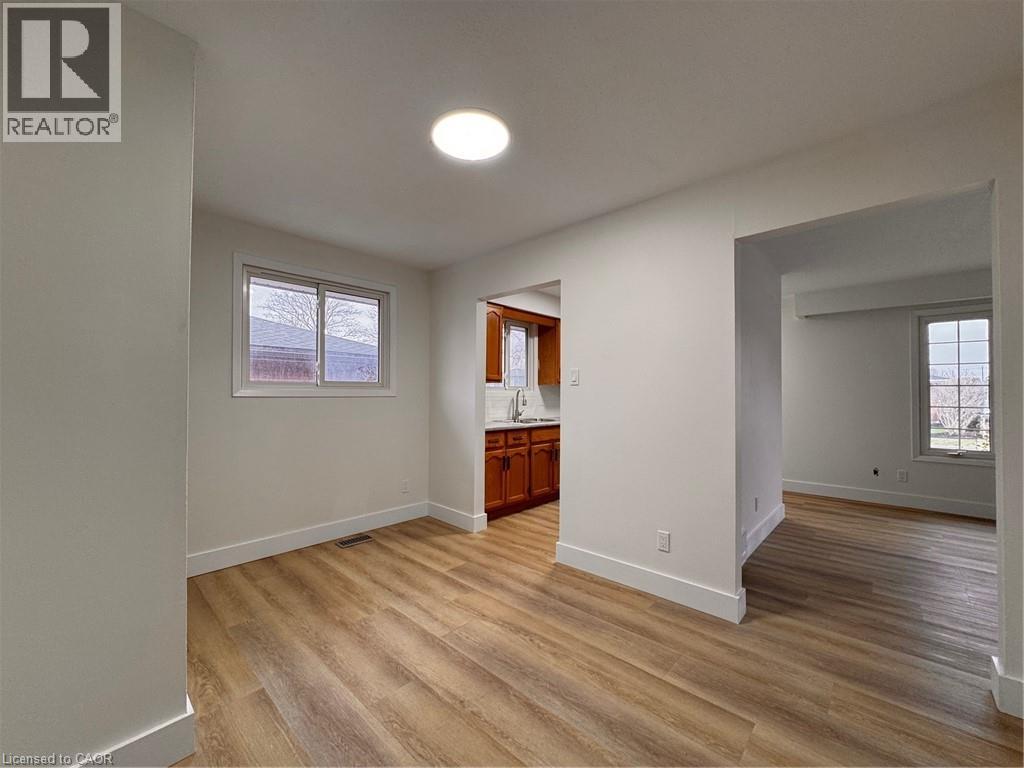 A spacious room with wooden flooring and a window.