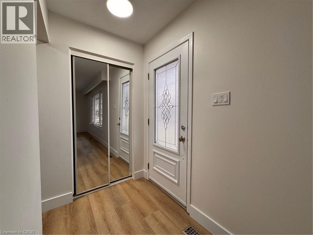 A hallway with a mirrored door and a white door.