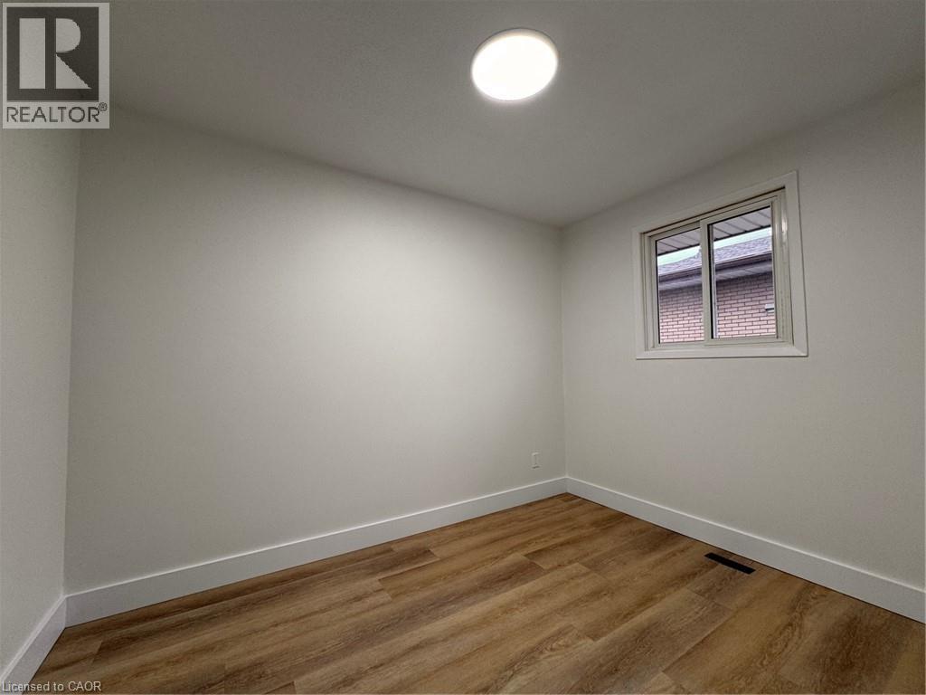 A room with a window and wooden flooring.