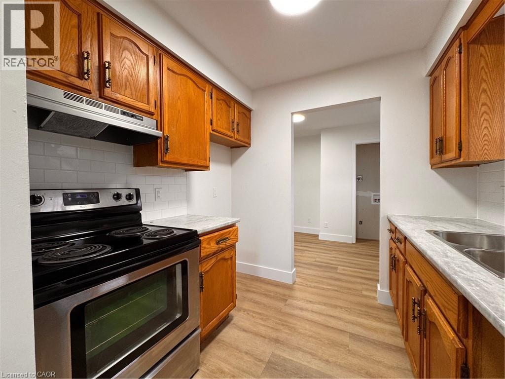 A kitchen with wooden cabinets and a stove top oven.