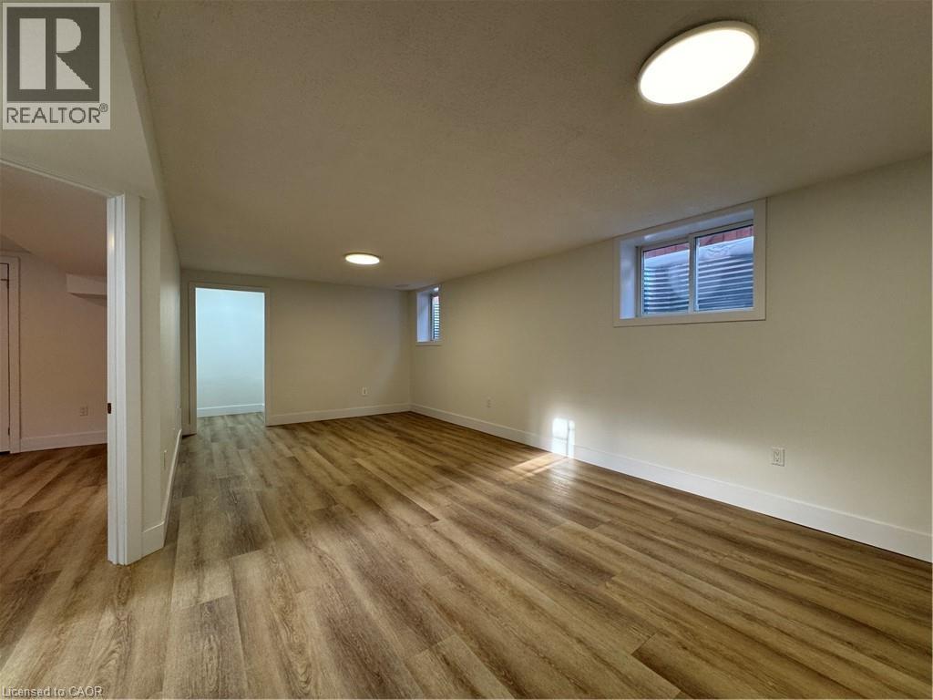 A room with wooden flooring and a window with blinds.