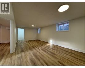 A room with wooden flooring and a window with blinds.