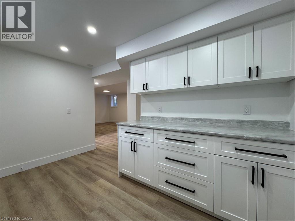 A kitchen with white cabinets and a marble countertop.