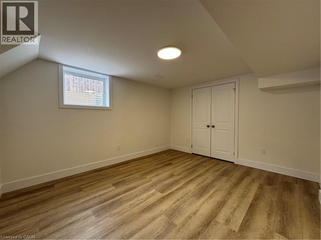 A room with wooden flooring and a window with blinds.