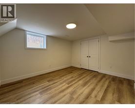 A room with wooden flooring and a window with blinds.
