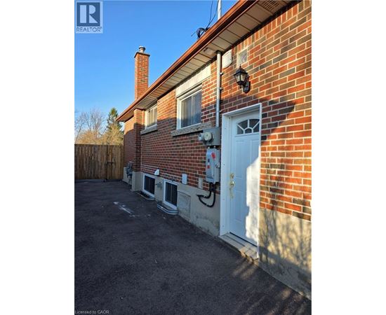 A red brick house with a white door and windows.
