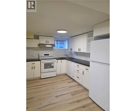 A kitchen with white appliances and wooden floors.