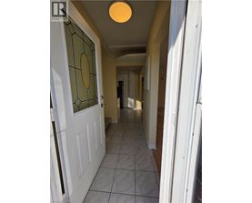 A hallway with a white door and a glass window.