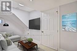 A living room with a couch, a coffee table, and a television.
