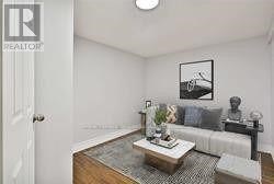 A living room with a couch, coffee table, and a painting on the wall.