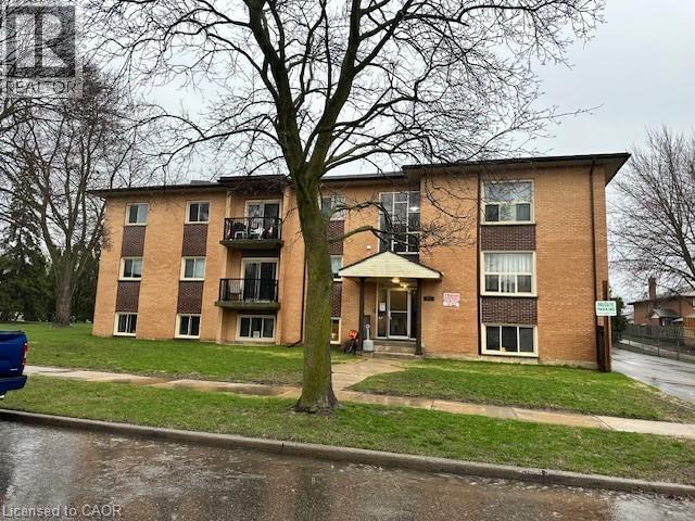 Apartment building with a tree in front of it.