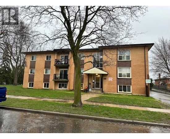 Apartment building with a tree in front of it.