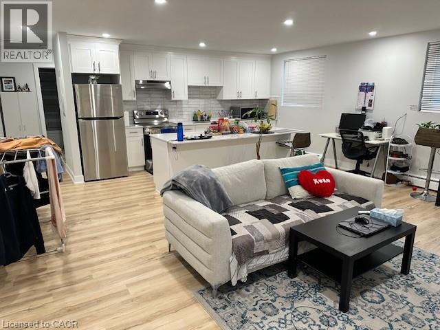 A living room with a couch, coffee table, and kitchen area in the background.