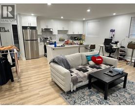 A living room with a couch, coffee table, and kitchen area in the background.