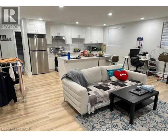 A living room with a couch, coffee table, and kitchen area in the background.