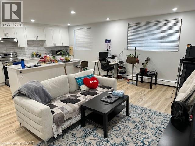 A living room with a couch, coffee table, and a kitchen area in the background.