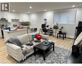 A living room with a couch, coffee table, and a kitchen area in the background.