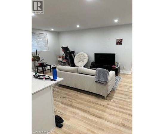 A living room with a white couch and a black chair.