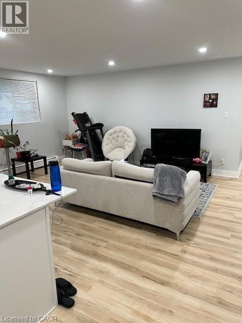 A living room with a white couch and a black chair.