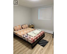 A bedroom with a bed, pillows, and a nightstand.