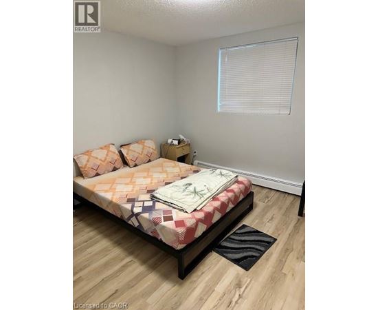 A bedroom with a bed, pillows, and a nightstand.