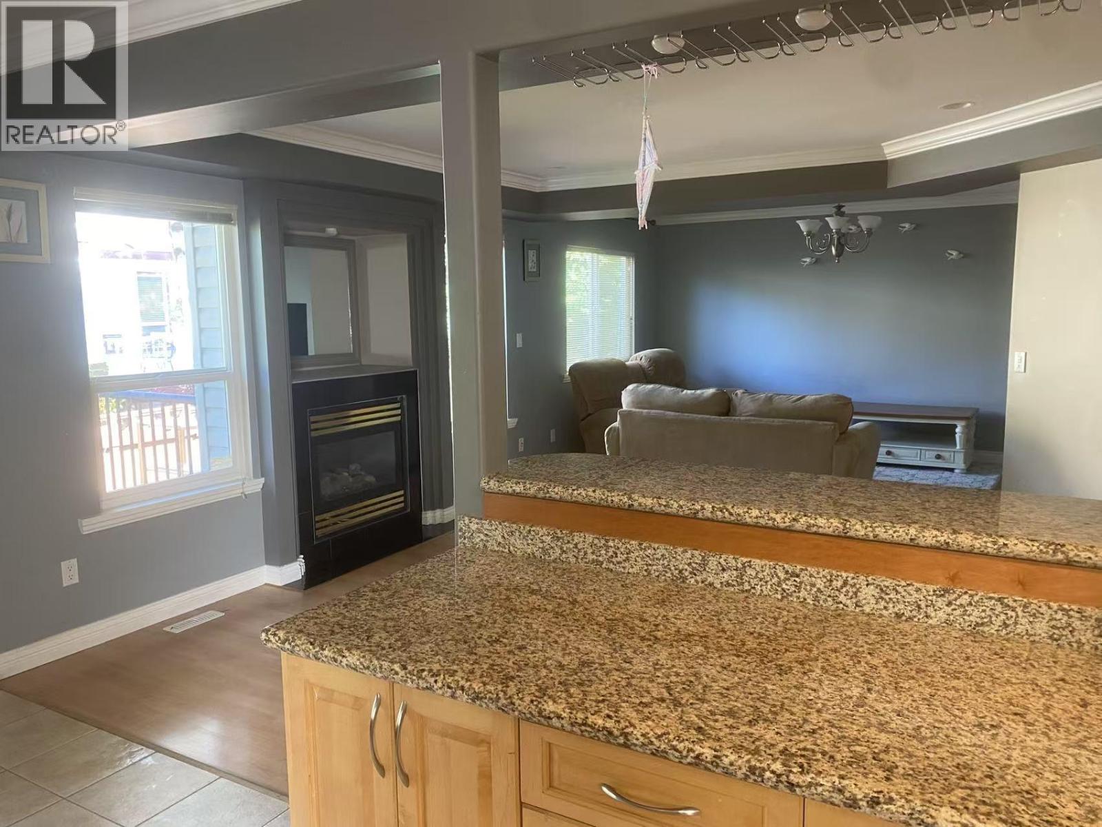 A kitchen with granite countertops and a wood stove.