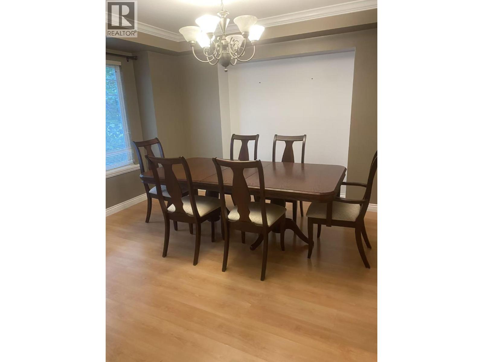 A dining room with a table and chairs.